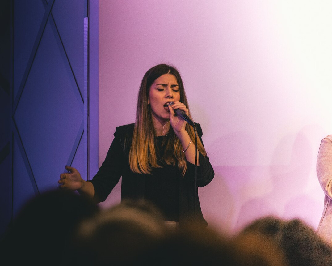 Confident woman giving a speech to an audience with a handheld microphone